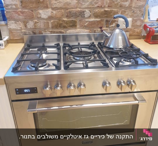 כיריים ותנור נירוסטה עם קומקום על הכיריים